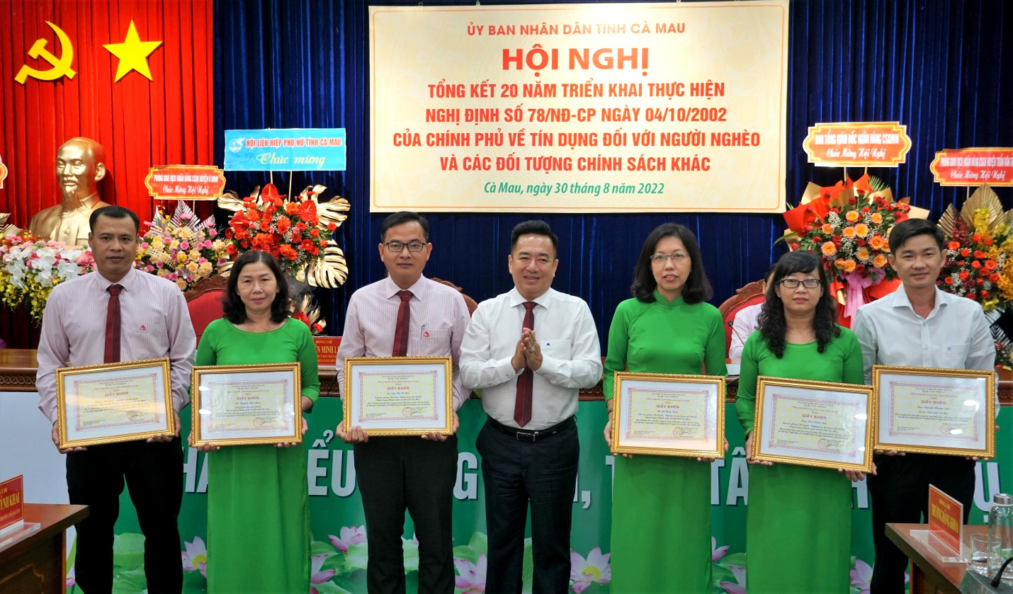 Đồng chí Huỳnh Văn Thuận, Phó Tổng Giám đốc Ngân hàng Chính sách xã hội Việt Nam (đứng giữa) trao các quyết định khen thưởng.